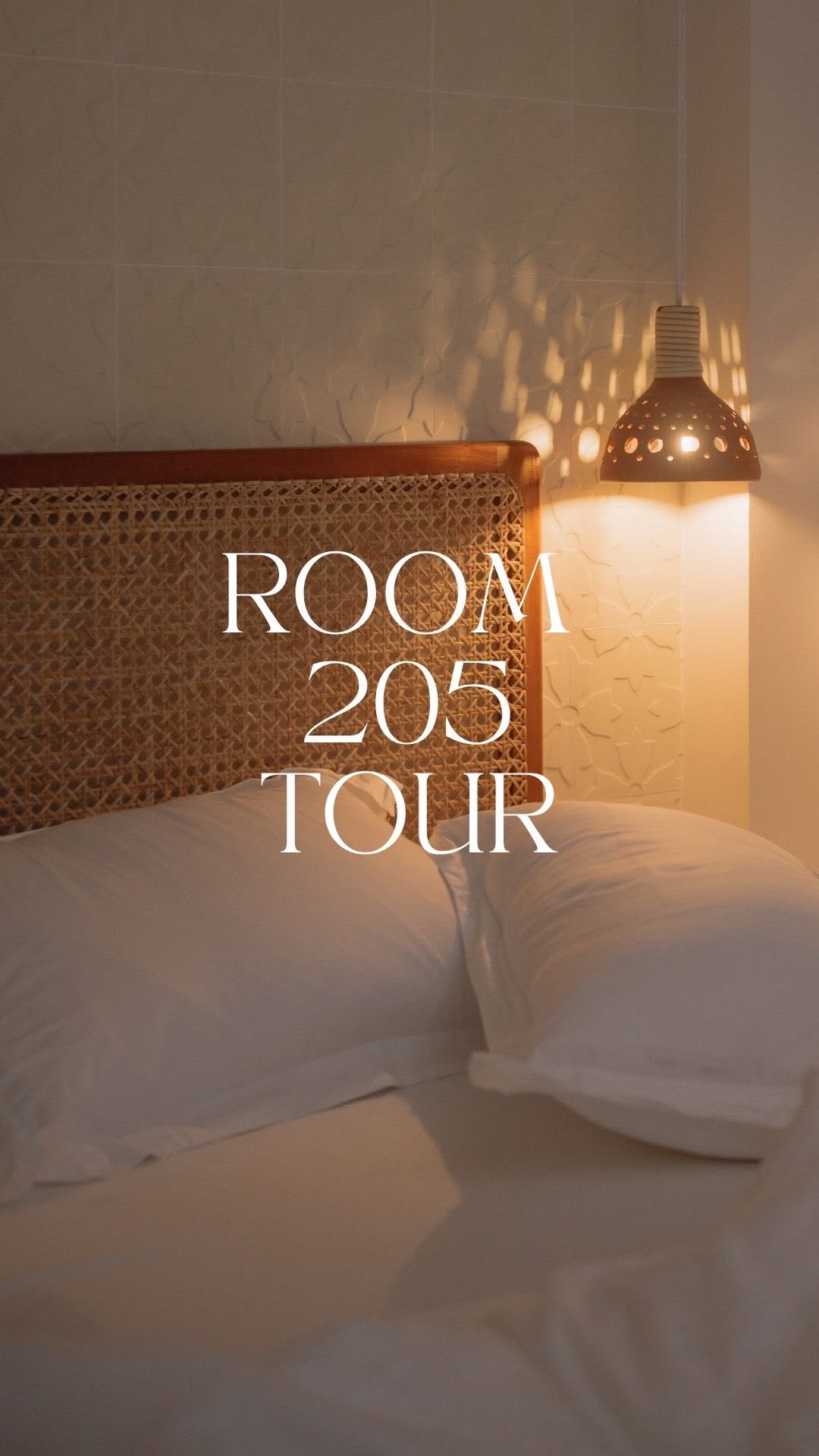 Room 205 rattan headboard with warm pendant lighting
