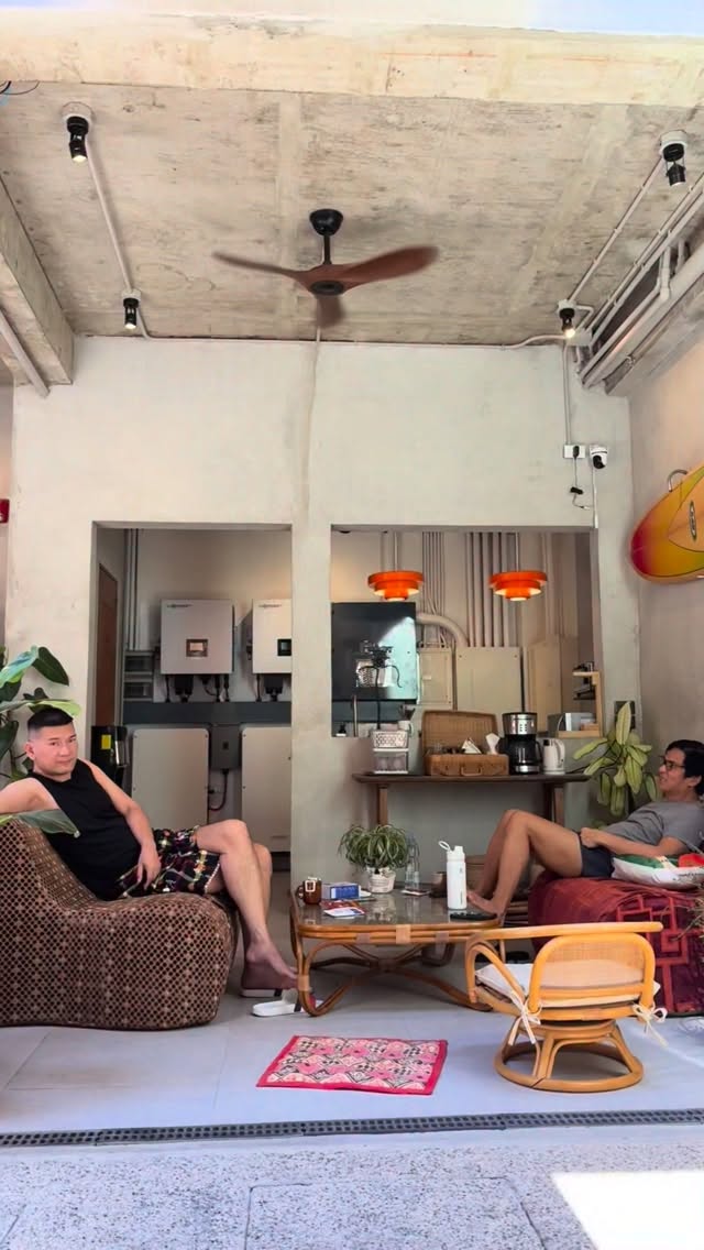 Guests relaxing in Grover's open common area with rattan chairs and ceiling fan